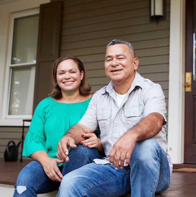Two Homeowners Sitting on Porch of Residence
