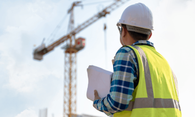 Construction Worker Looking at Building Crane